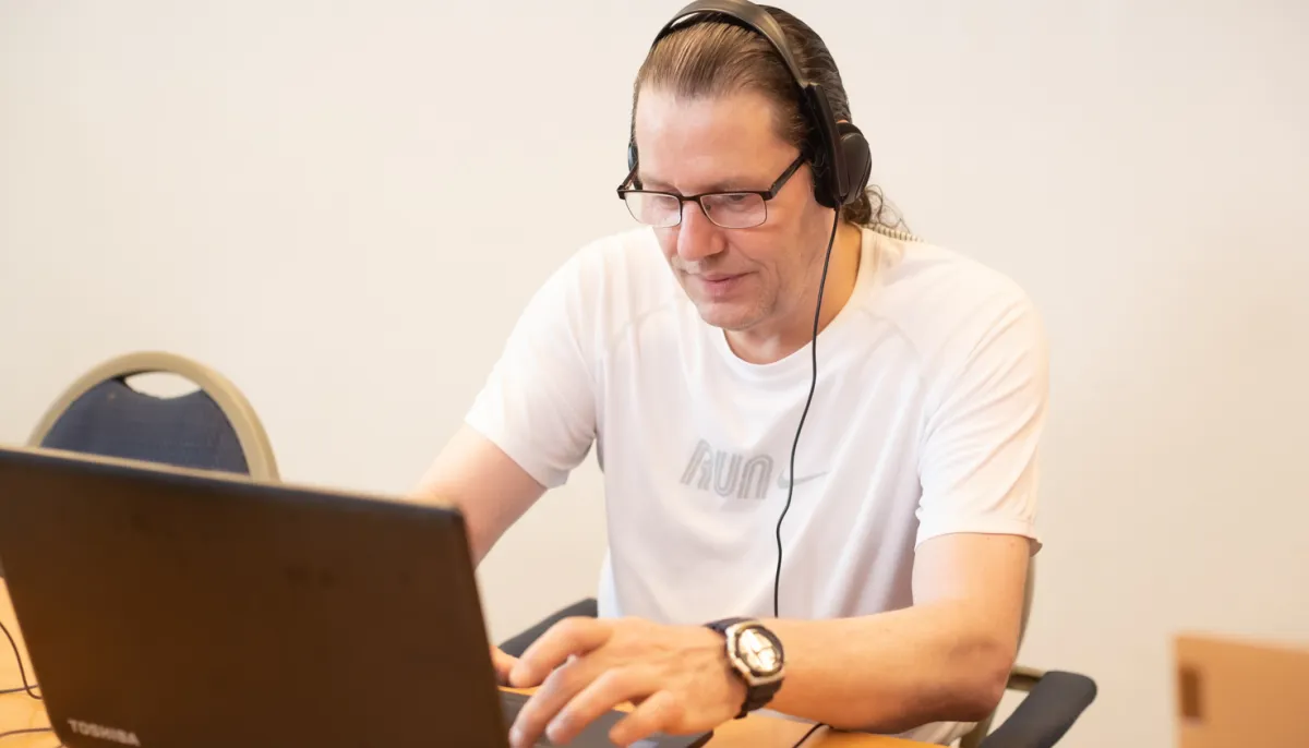 man achter pc met koptelefoon