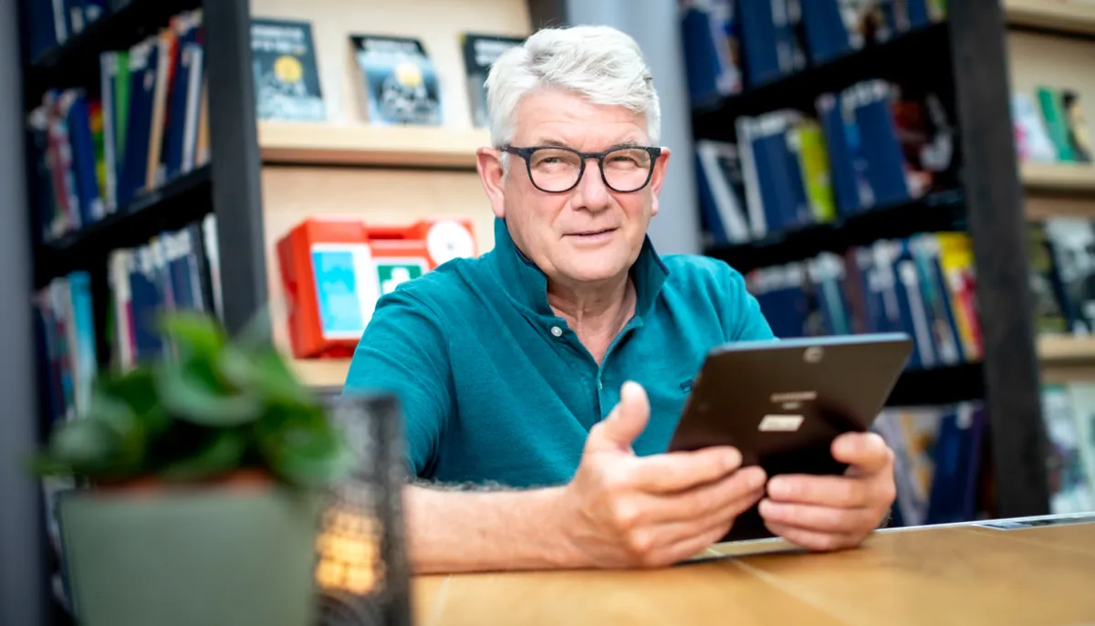Man met ipad aan tafel 