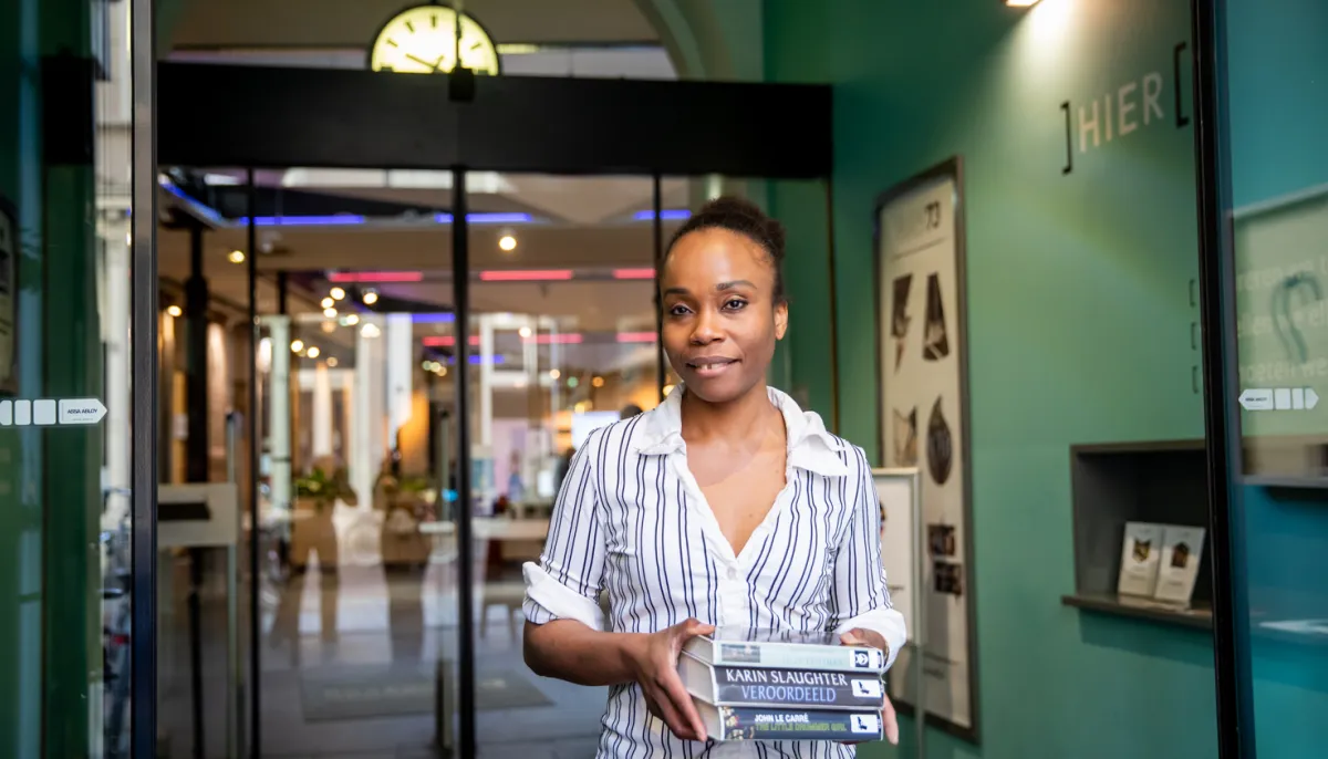 vrouw in ingang met stapel boeken