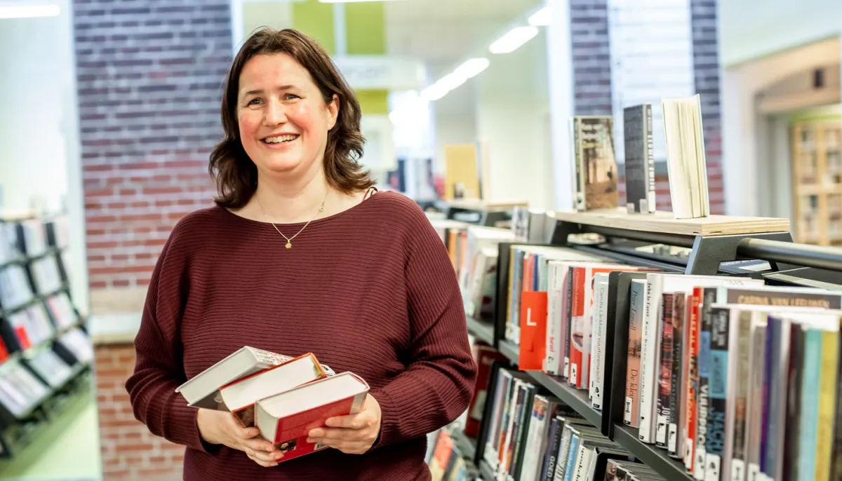 vrouw met boek voor boekenkast