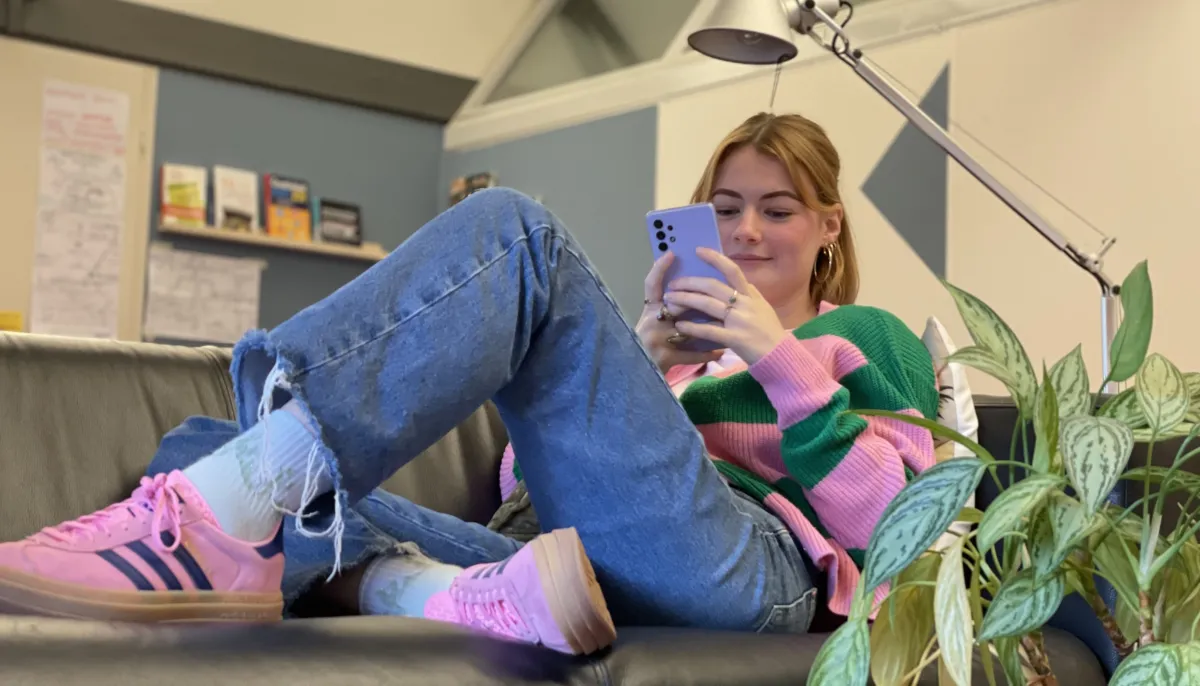 vrouw op bank met mobiel 