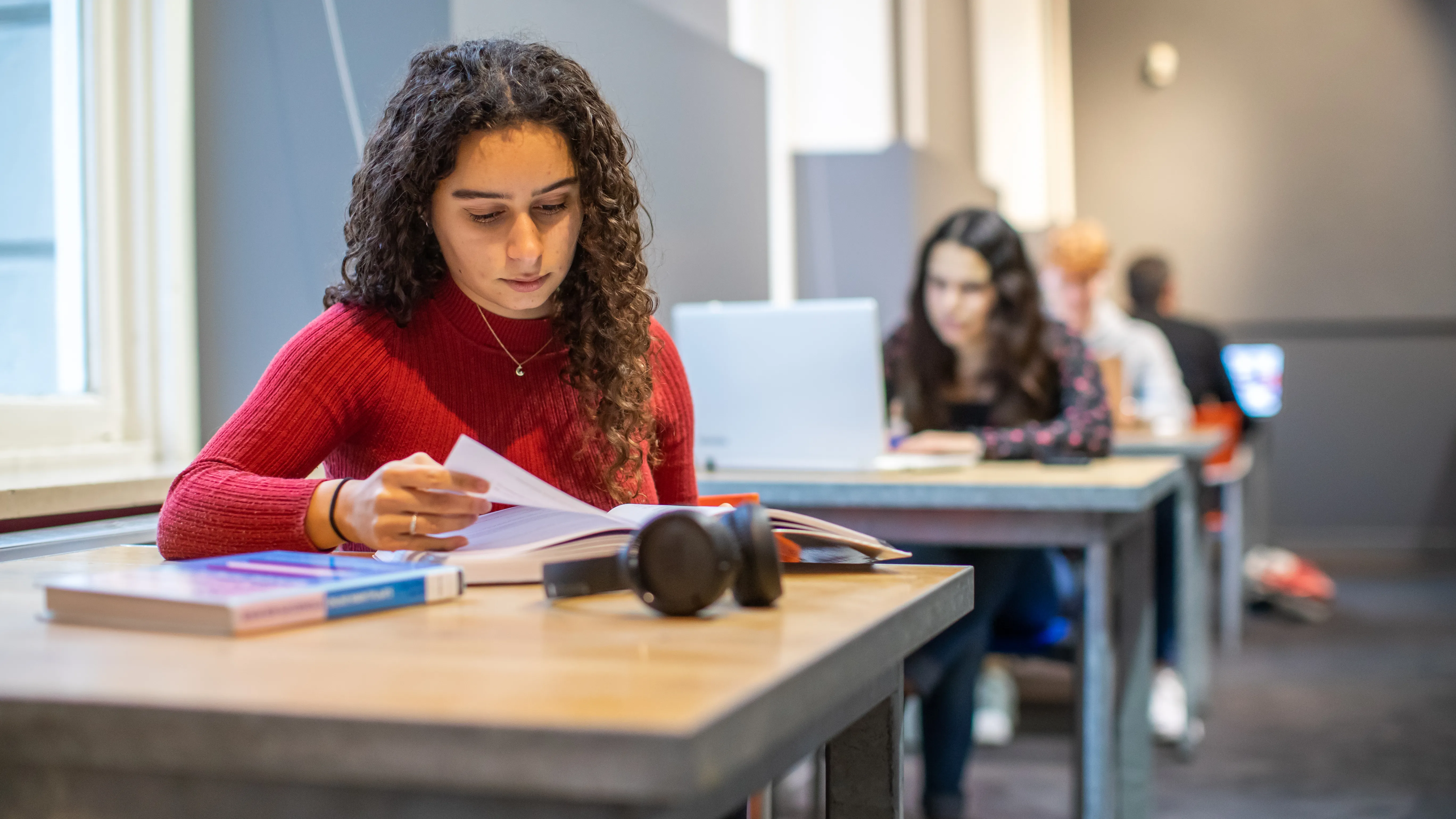 twee jonge meiden aan het studeren met boek en laptop