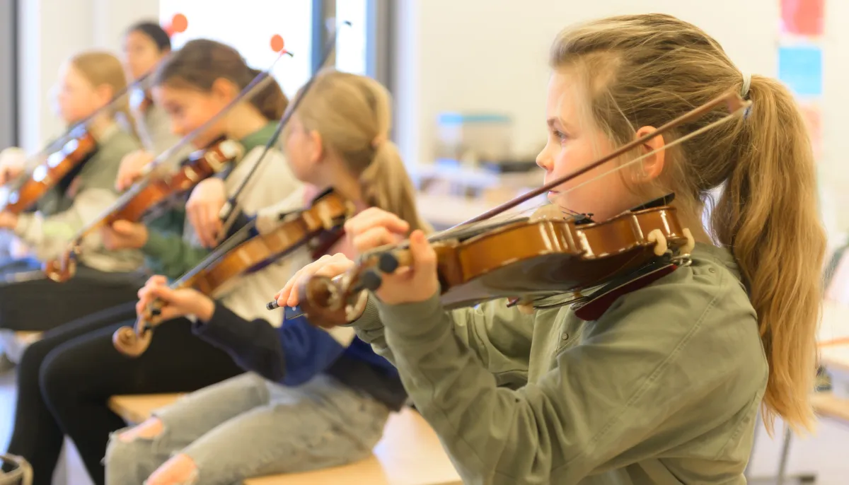 Leerlingen leren viool spelen