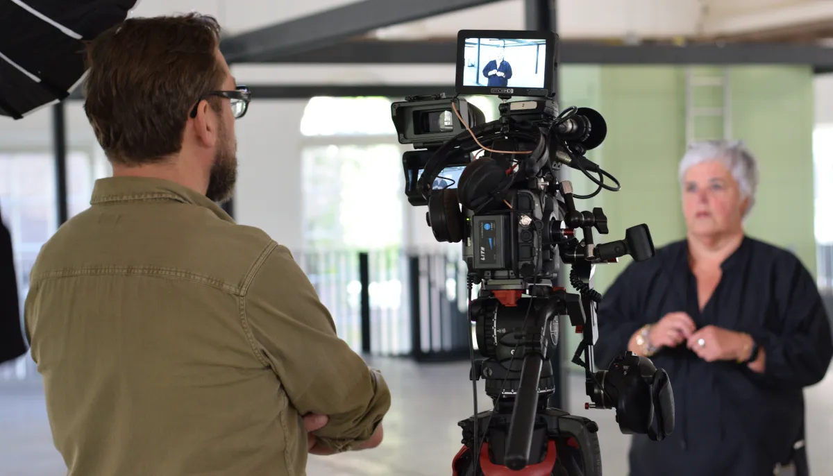 cameraman met camera interviewt collega Jose