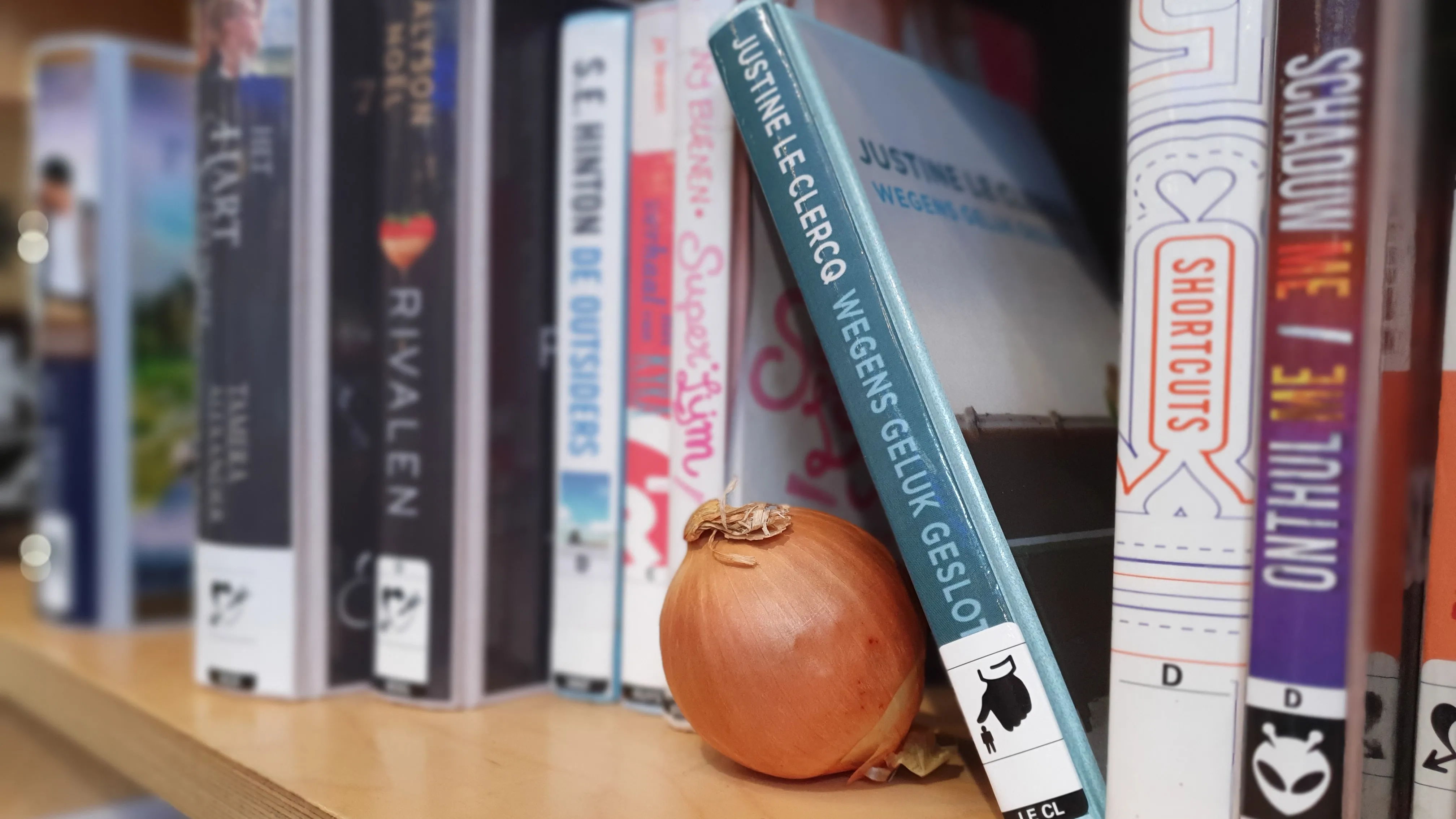 gele ui op boekenplank met boeken