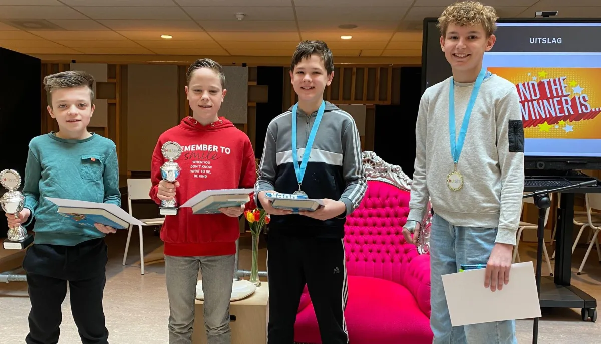 vier jongens met hun boek op podium