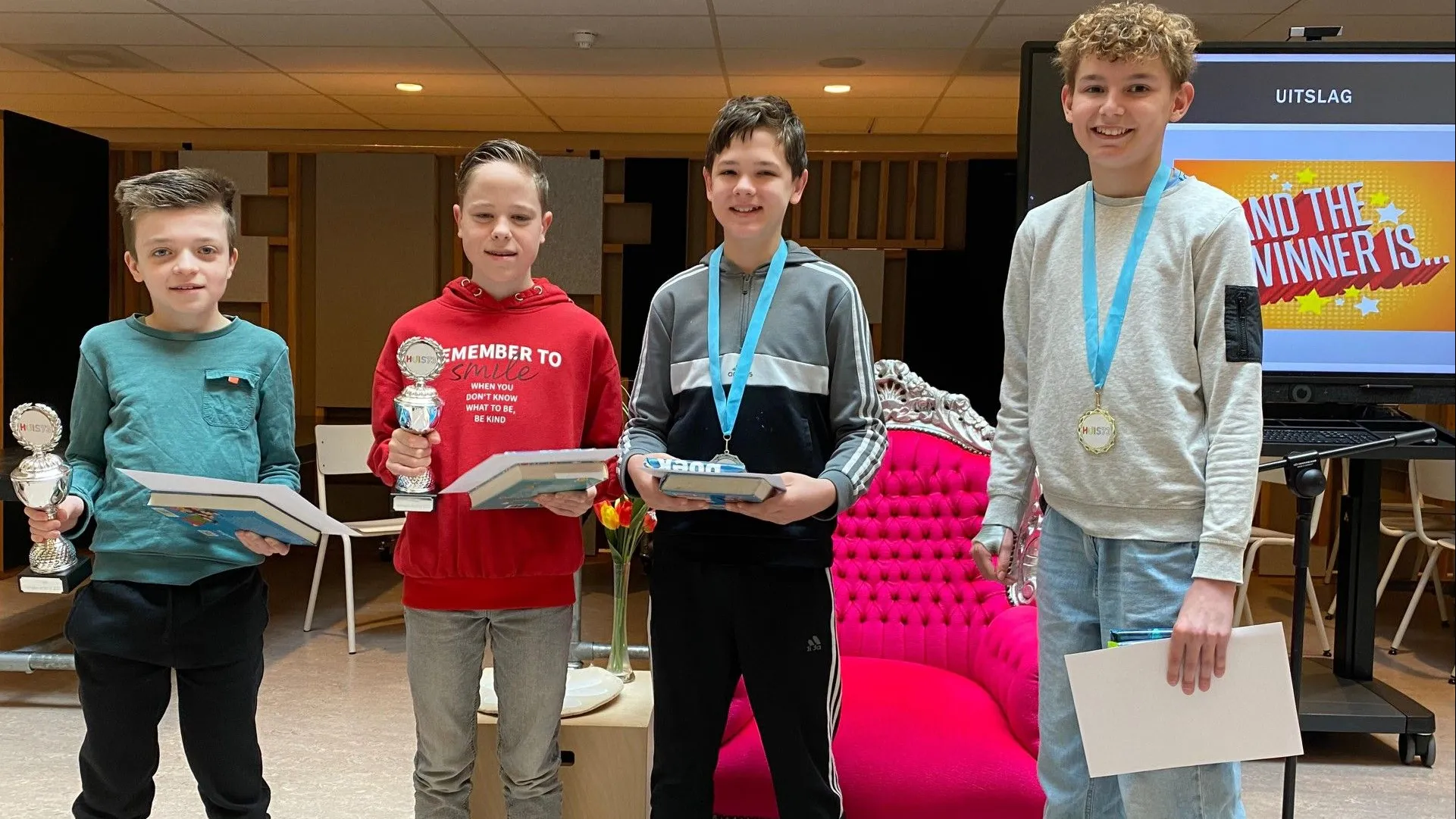 vier jongens met hun boek op podium