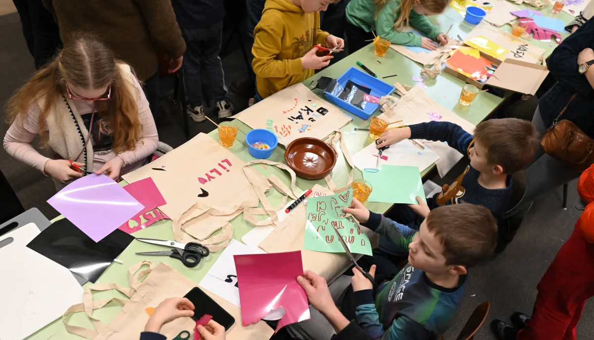 Kinderen knutselend aan tafel in werkplaats