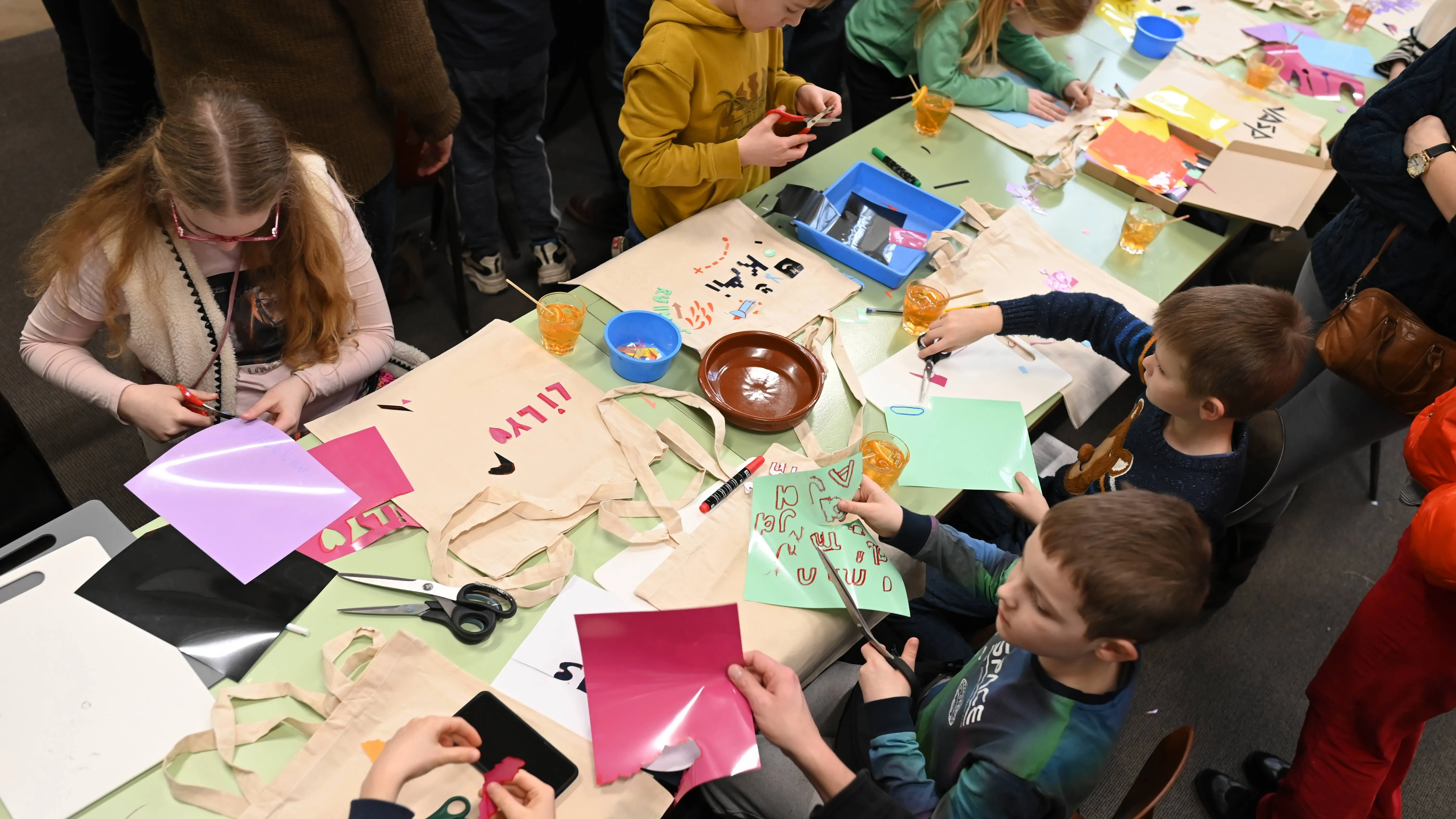 Kinderen knutselend aan tafel in werkplaats