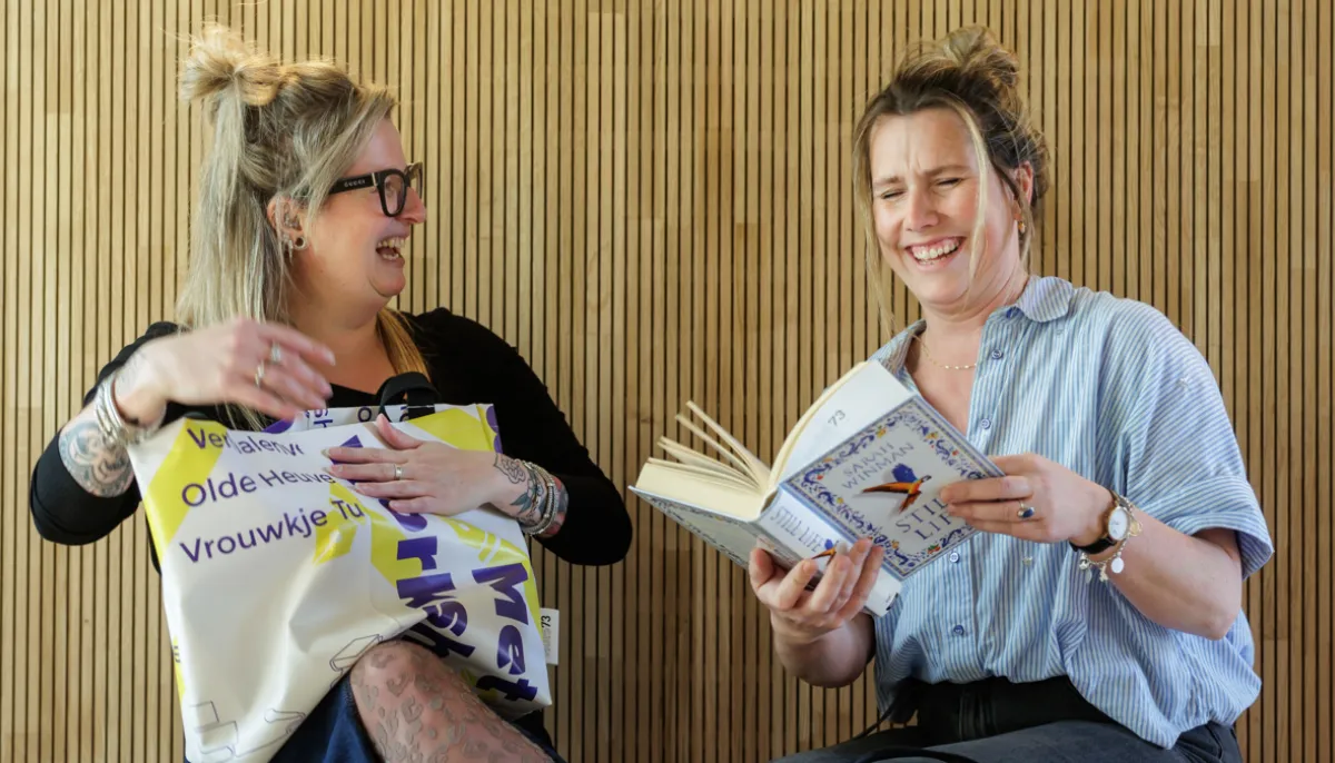 twee jongen vrouwen zittend met boek