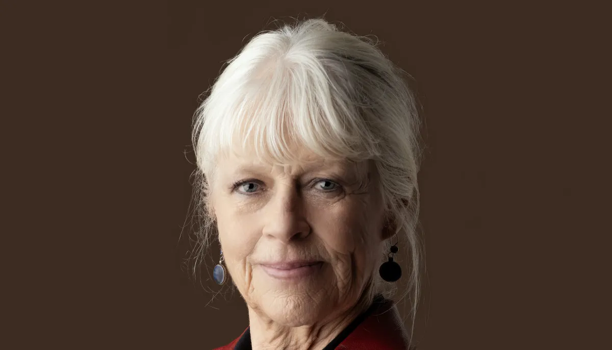 Portret van schrijfster Annegreet van Bergen. Grijze vrouw in rode jas