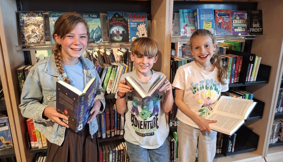 3 kinderen met boek in hand