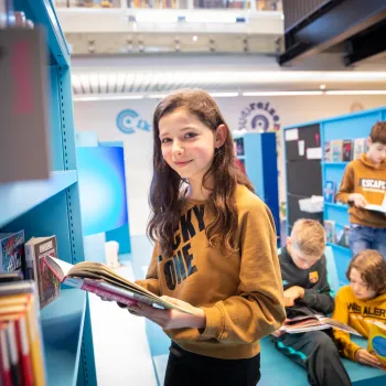 Kinderen meisje in blauwe gang met boek
