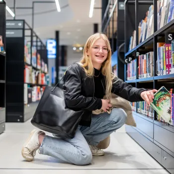 Bibliotheek Vught jongeren meisje knielend bij boekenrek
