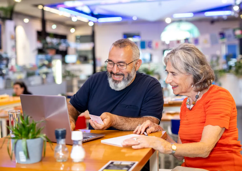 man en vrouw aan tafel achter laptop