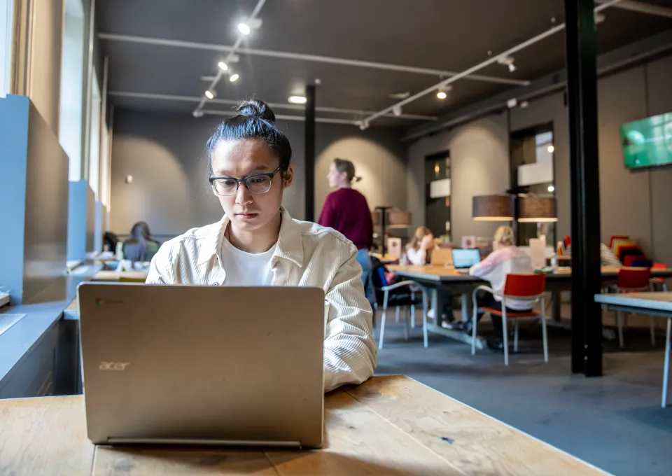 jongen achter computer in studiezaal