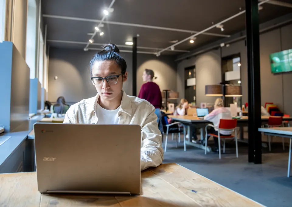jongen achter computer in studiezaal