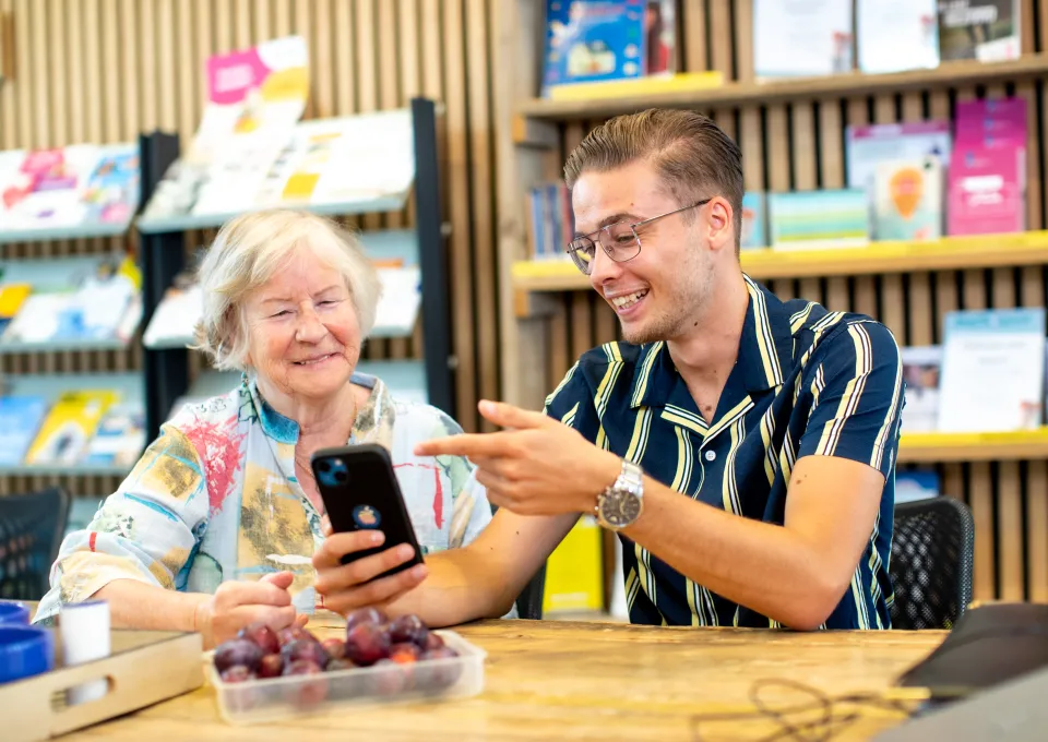 Vrouw en man achter telefoon in Digitaalpunt