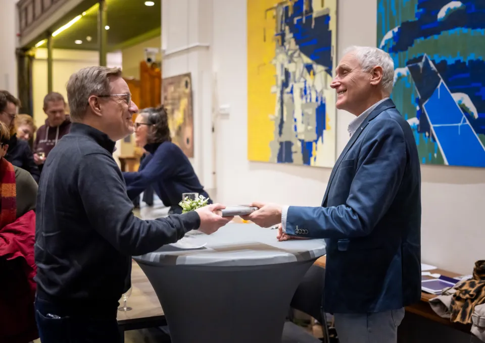 schrijver geeft boek aan bezoeker