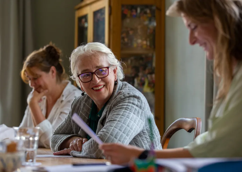 vrouwen rond tafel lezen en praten met eklaar