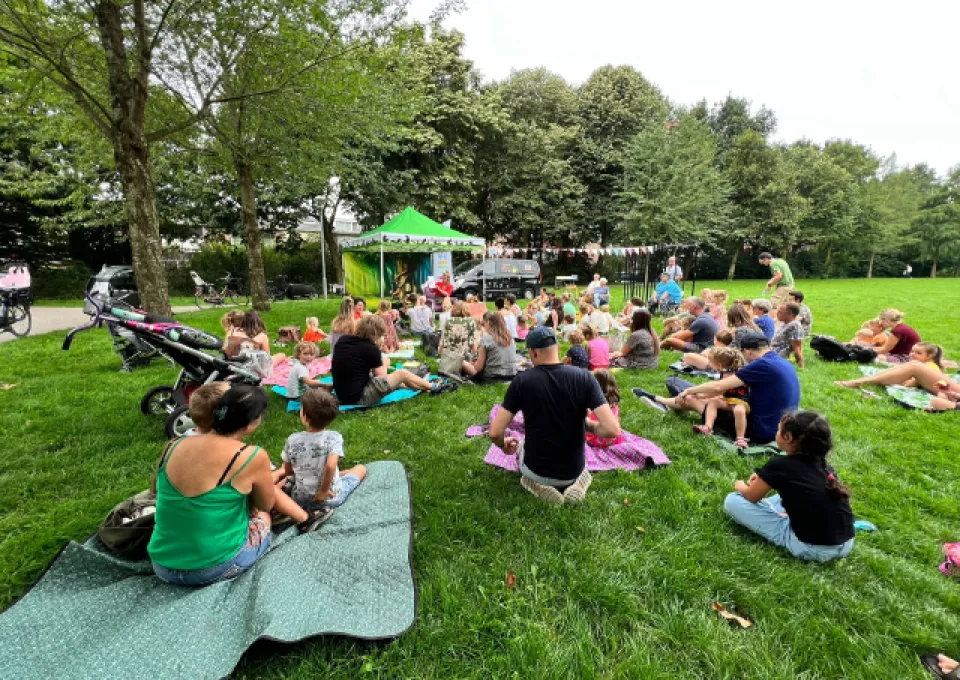 kinderen en ouders op grasveld voor tent