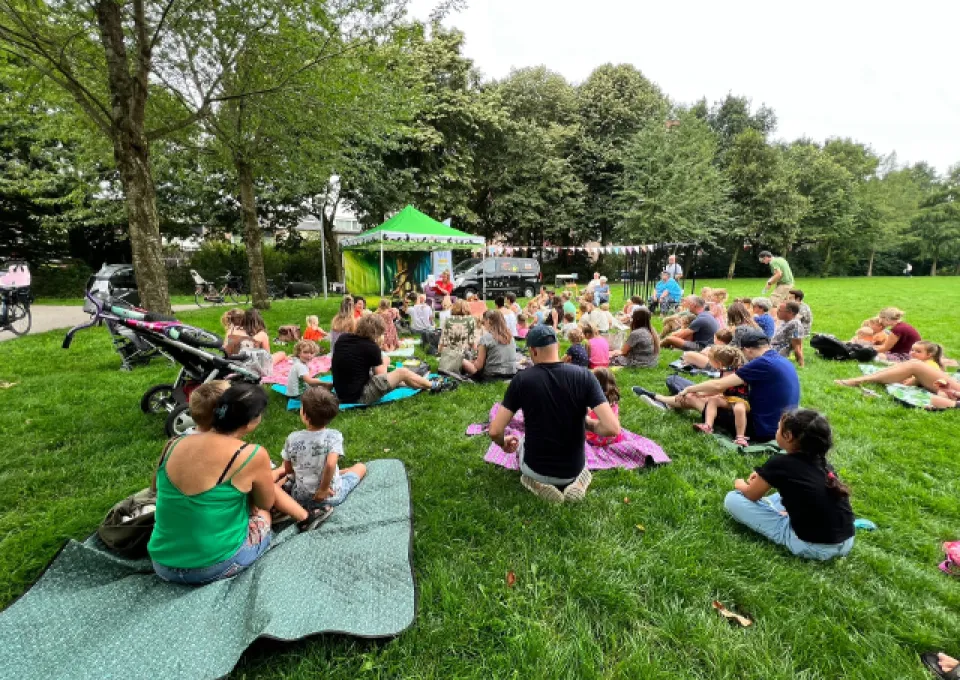 kinderen en ouders op grasveld voor tent