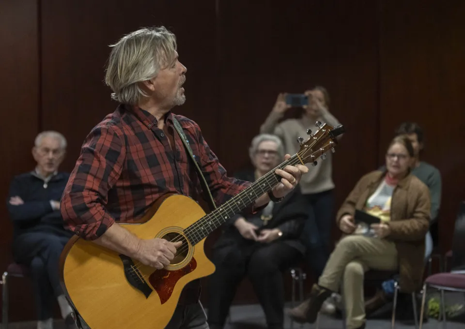 Man met gitaar en publiek