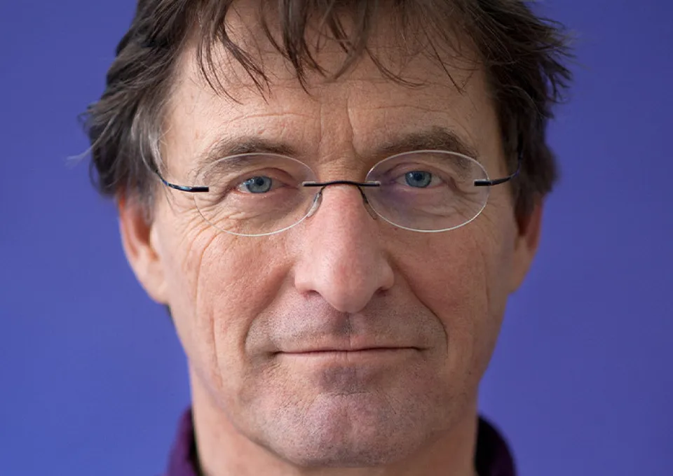 portret auteur tegen blauwe achtergrond