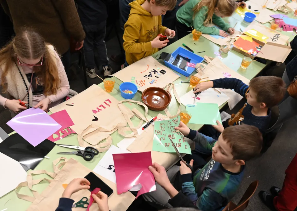 Kinderen knutselend aan tafel in werkplaats