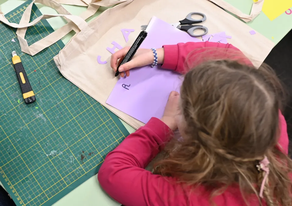 kind tekent op paars papier 