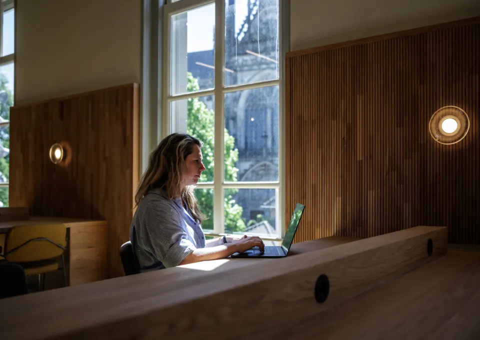 vrouw met laptop en uitzicht op Sint-Jan