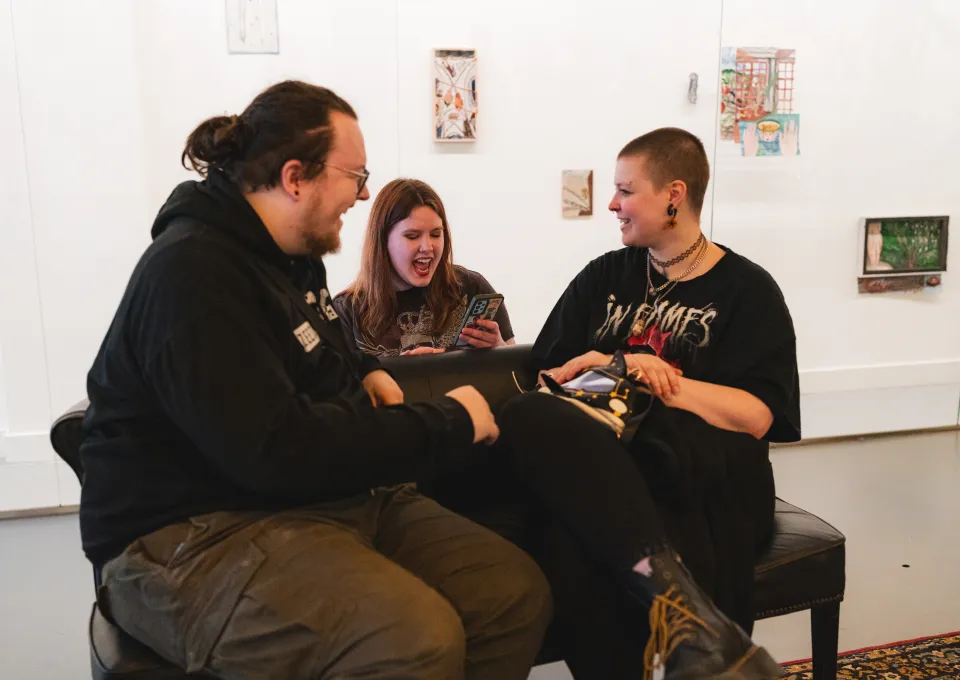 Drie jongeren lachen en chillen op een bank 