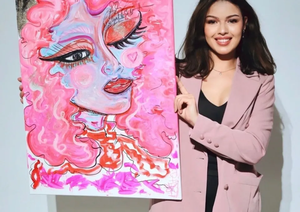 Foto van vrouw die schilderij (roze) vasthoudt