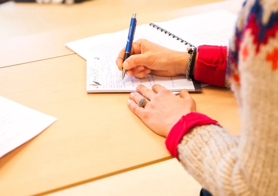 iemand aan tafel zit te schrijven
