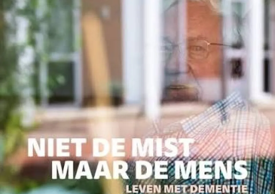 Oudere man die uit het raam kijkt