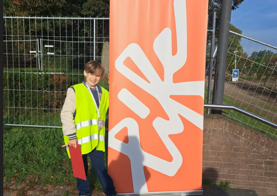 Jongen bij banner buiten 