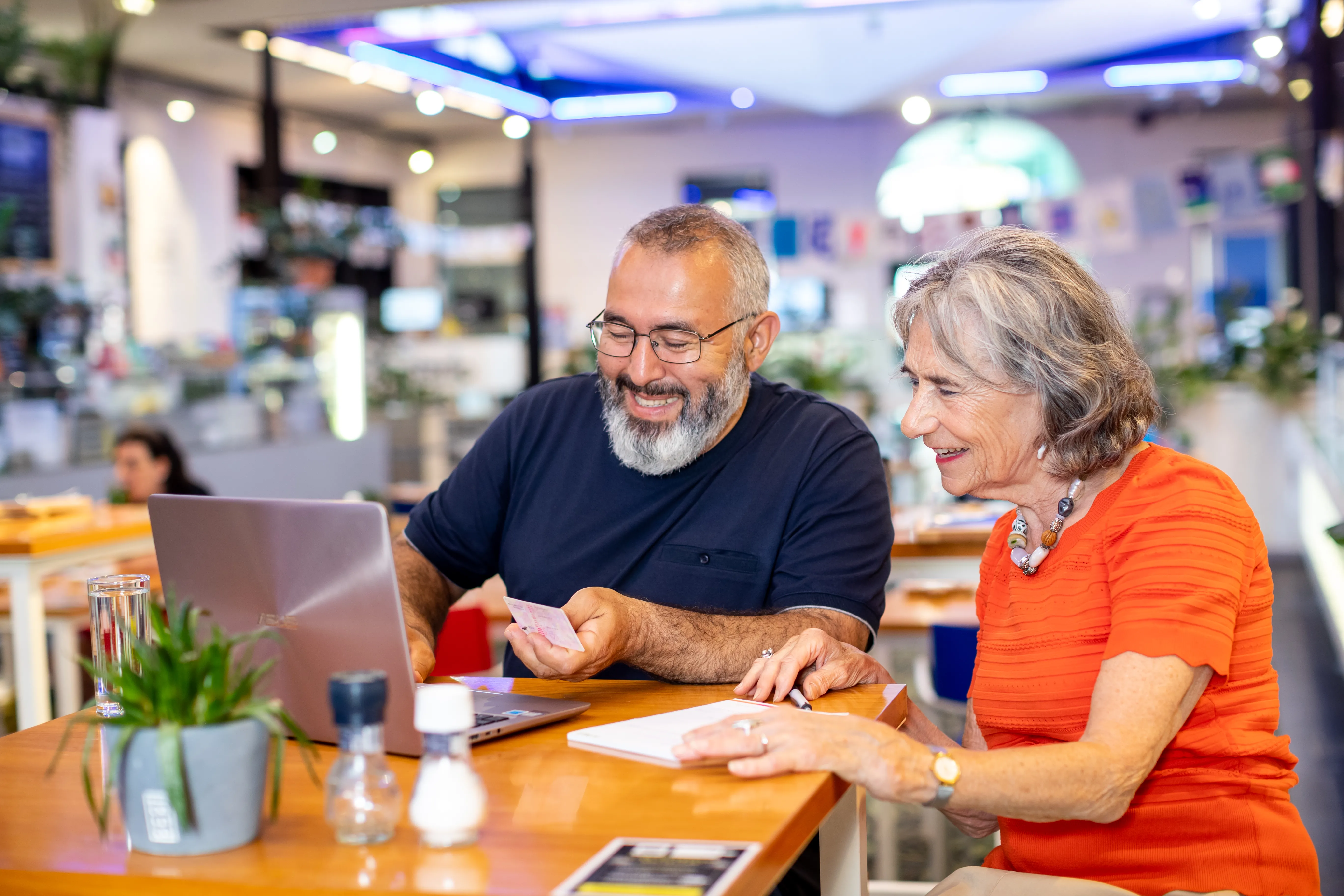 man en vrouw aan tafel achter laptop