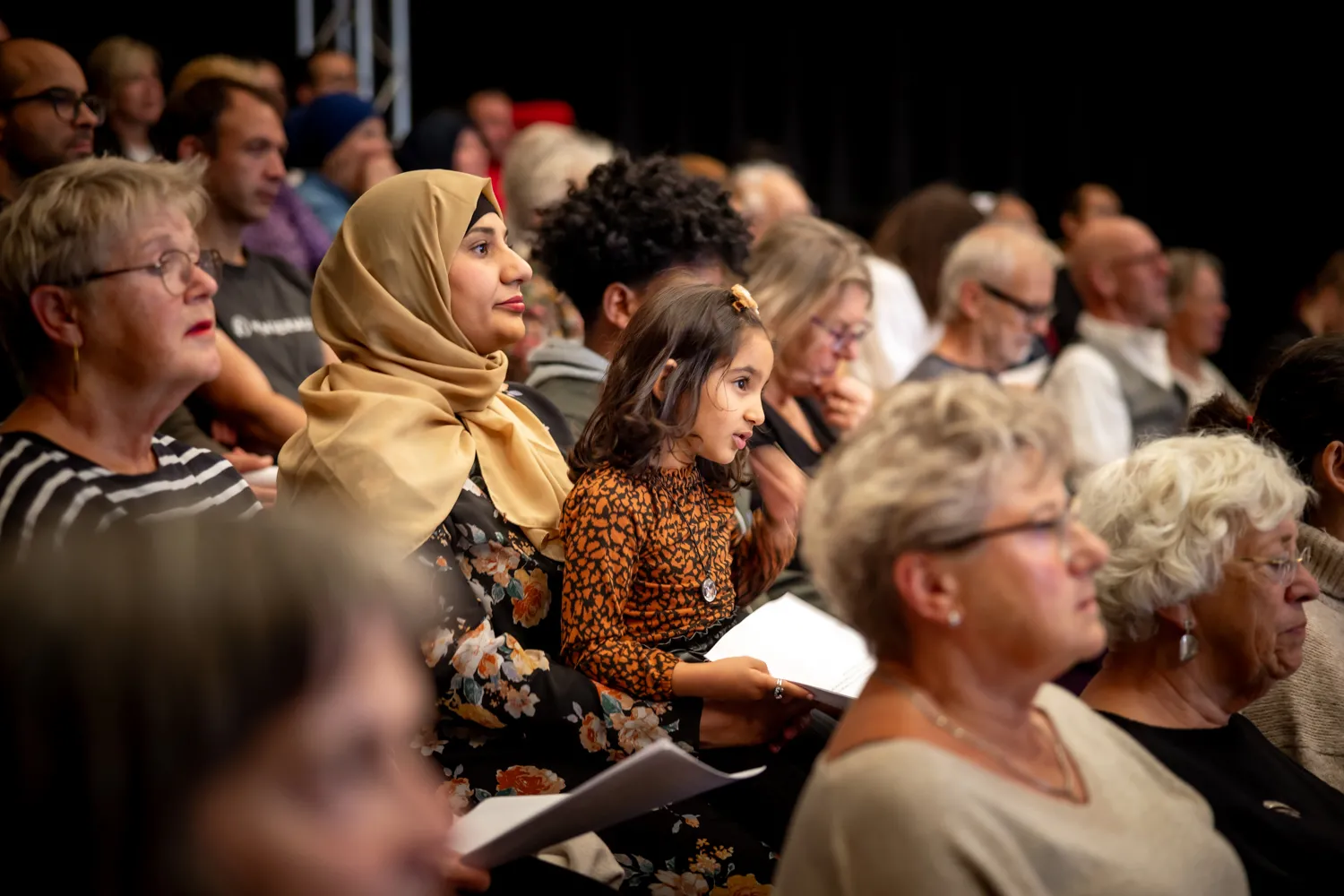 foto van zijaanzicht gevarieerd publiek in zaal