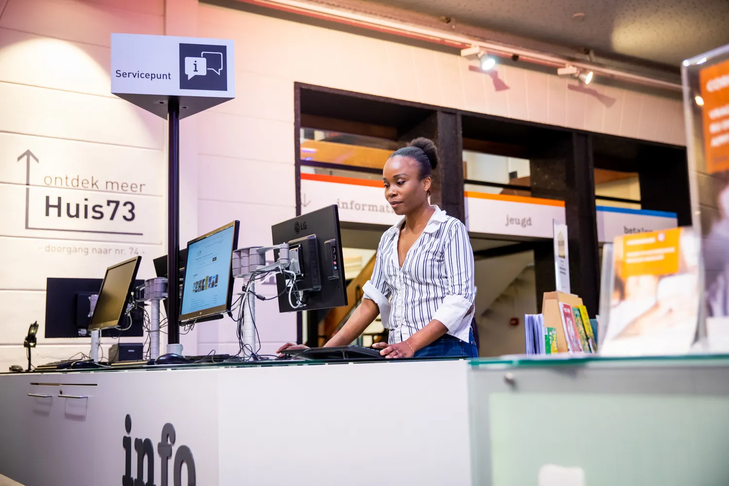 Vrouw achter computer in bibliotheek