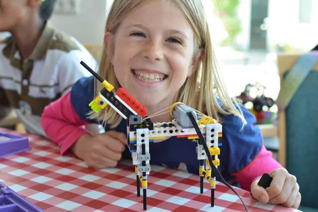 Meisje toont blij haar gemaakte bricks creatie