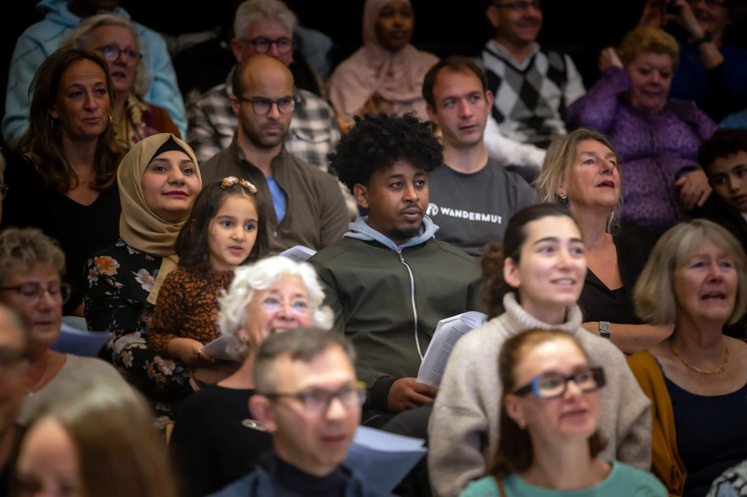 Verschillende mensen in een publiek die meezingen