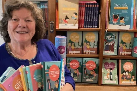 Hetty met haar boeken bij de boekenkast