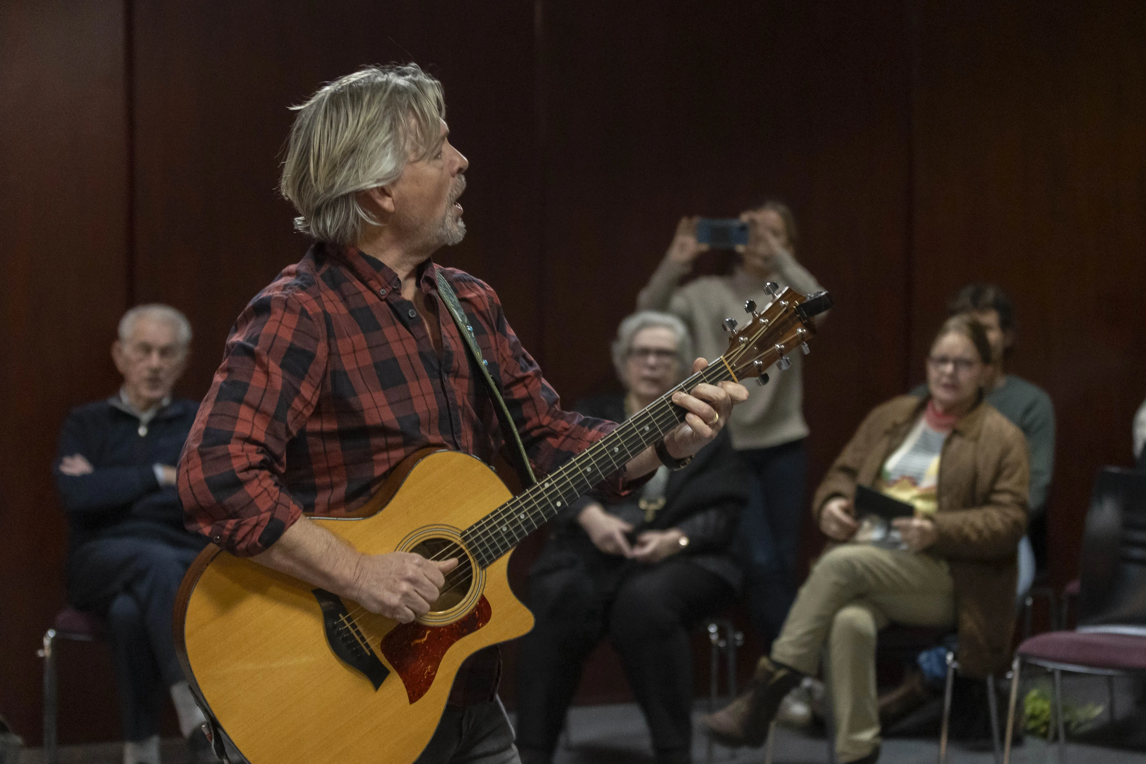Man met gitaar en publiek
