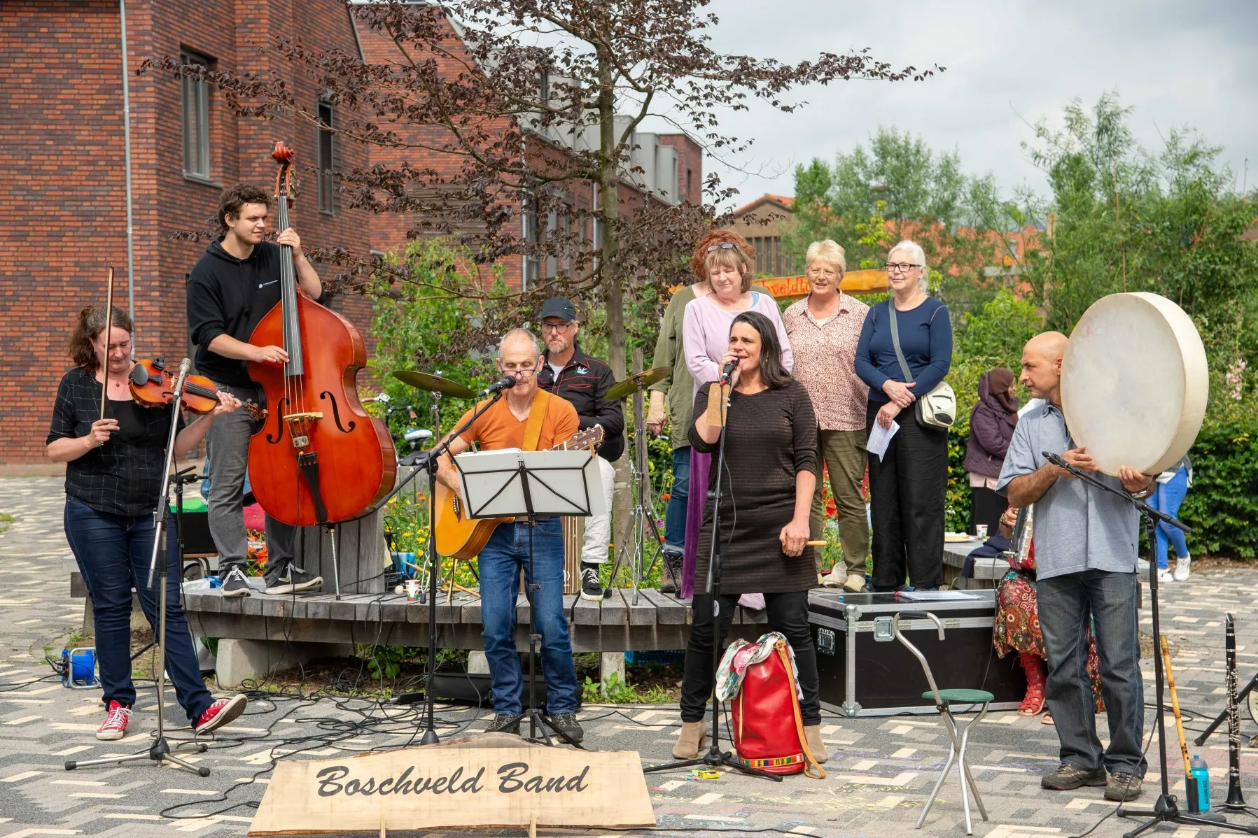 Bandleden van Boschveldband buiten aan het spelen op instrumenten