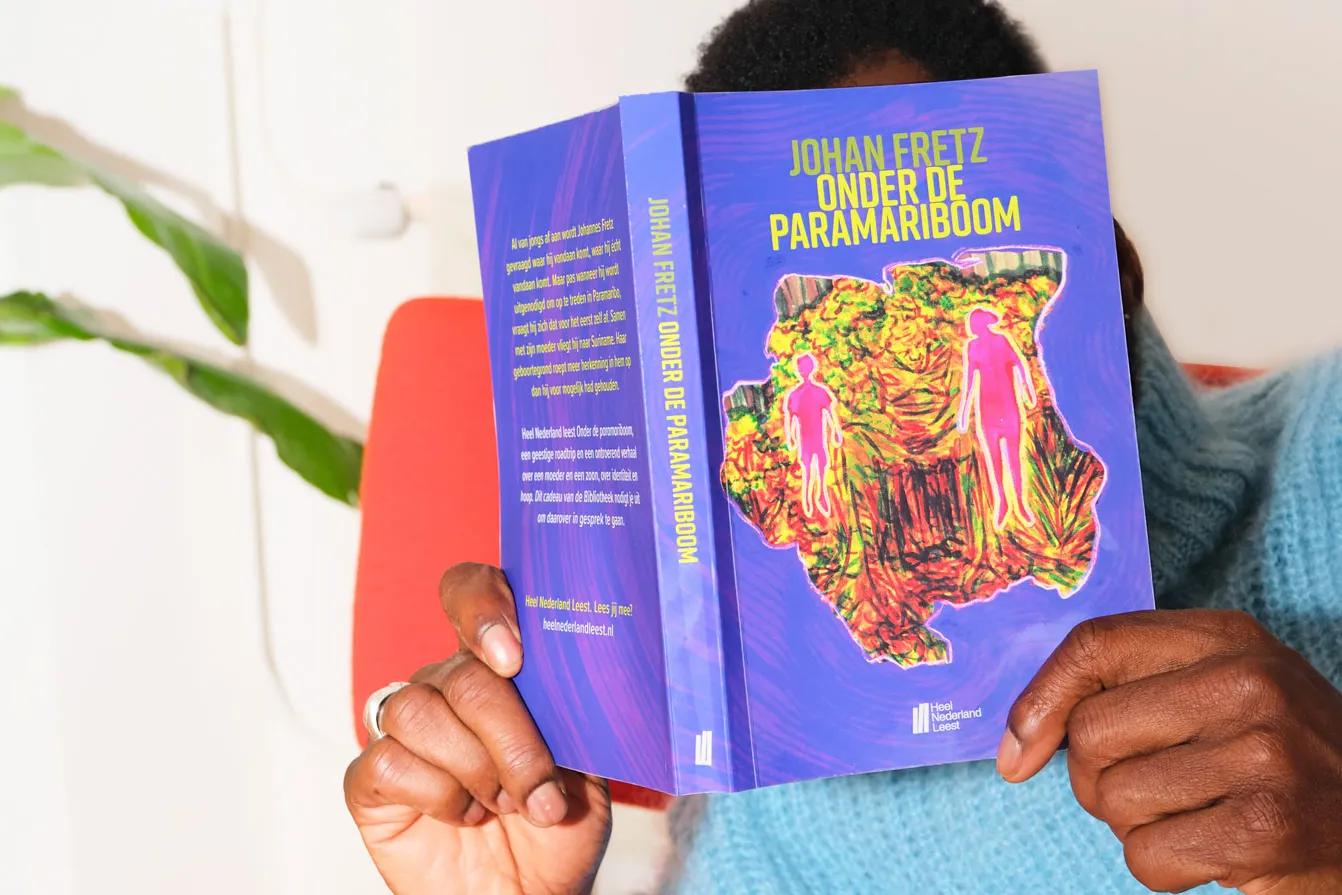 Iemand die het boek onder de paramariboom leest