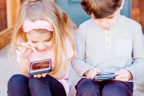twee kinderen op hun mobiel