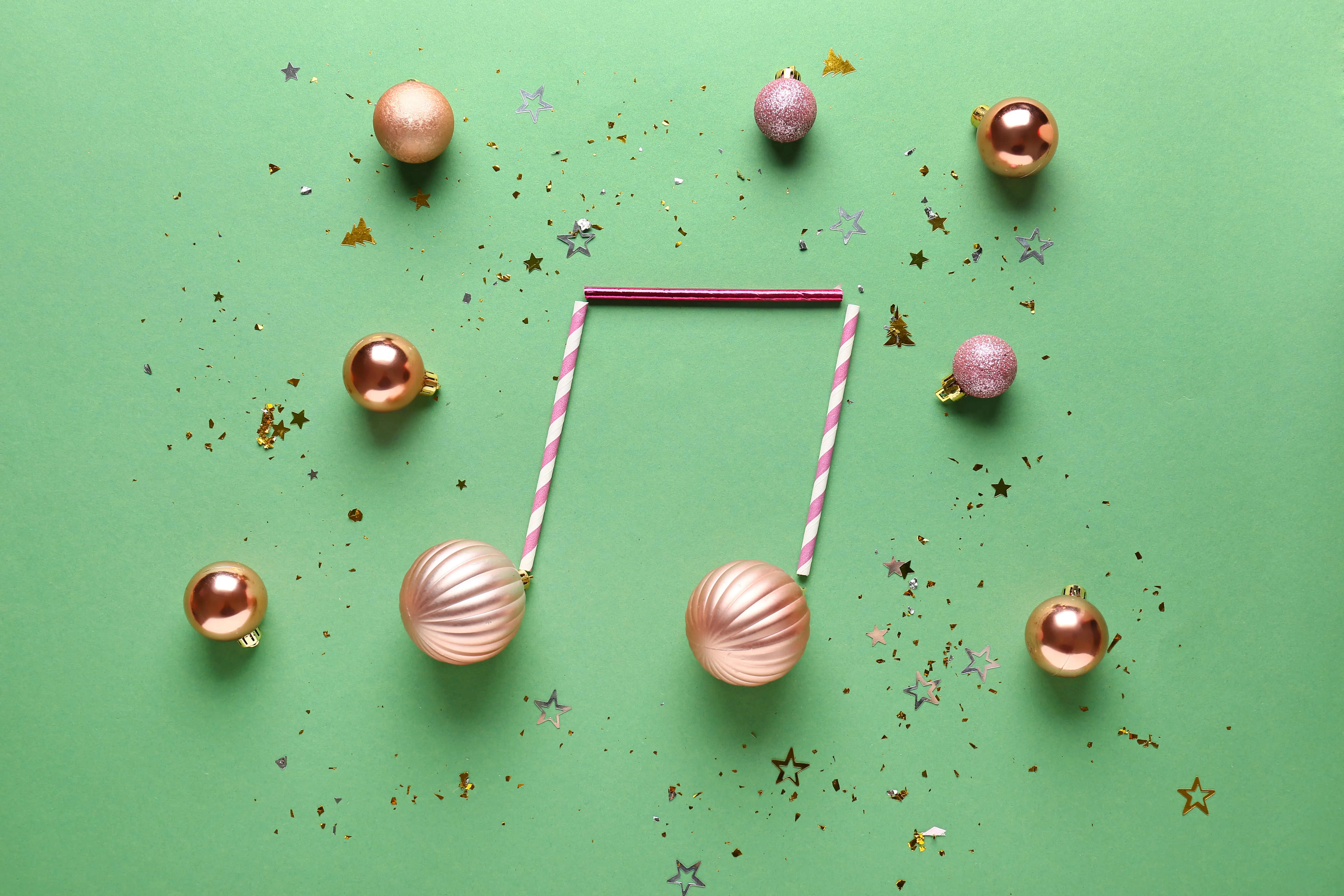 Groene achtergrond met kerstballen in vorm van muzieknoot