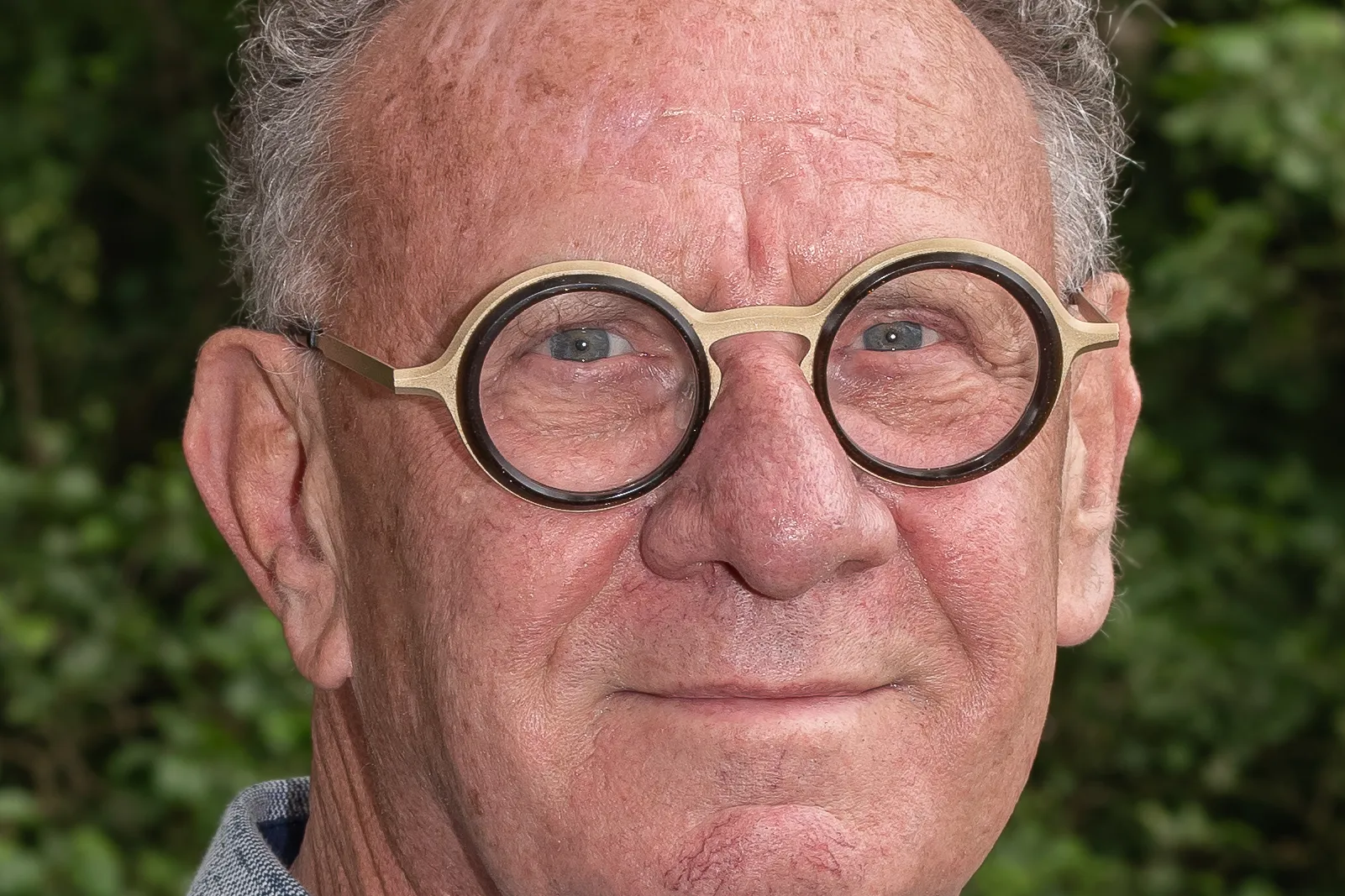 Man met grijs haar en bril.