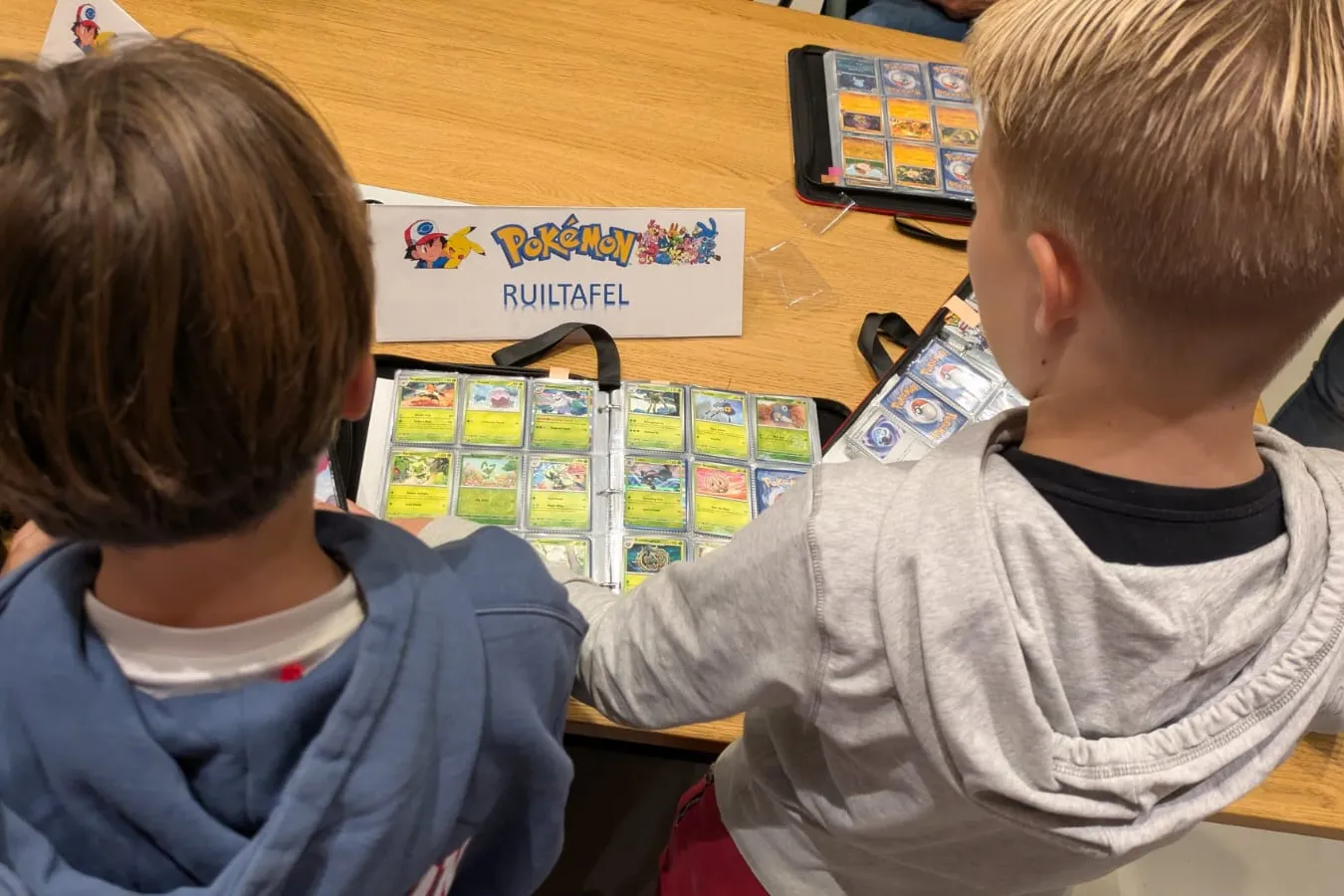jongens ruilen pokemonkaarten