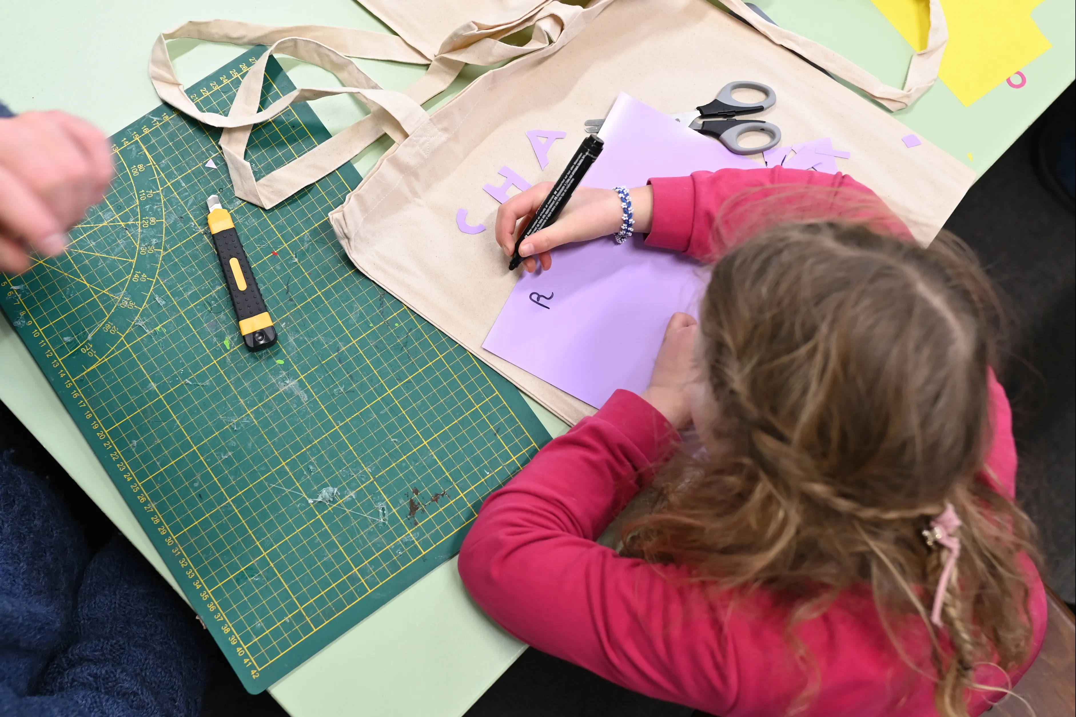 kind tekent op paars papier 